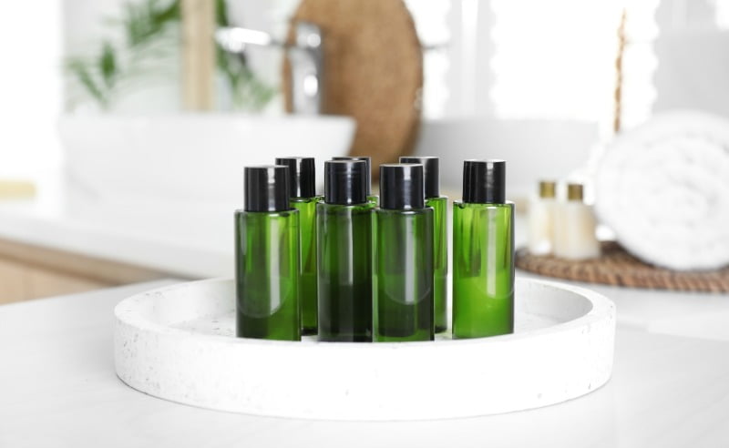 toiletry bottles on tray on marble bathroom countertop